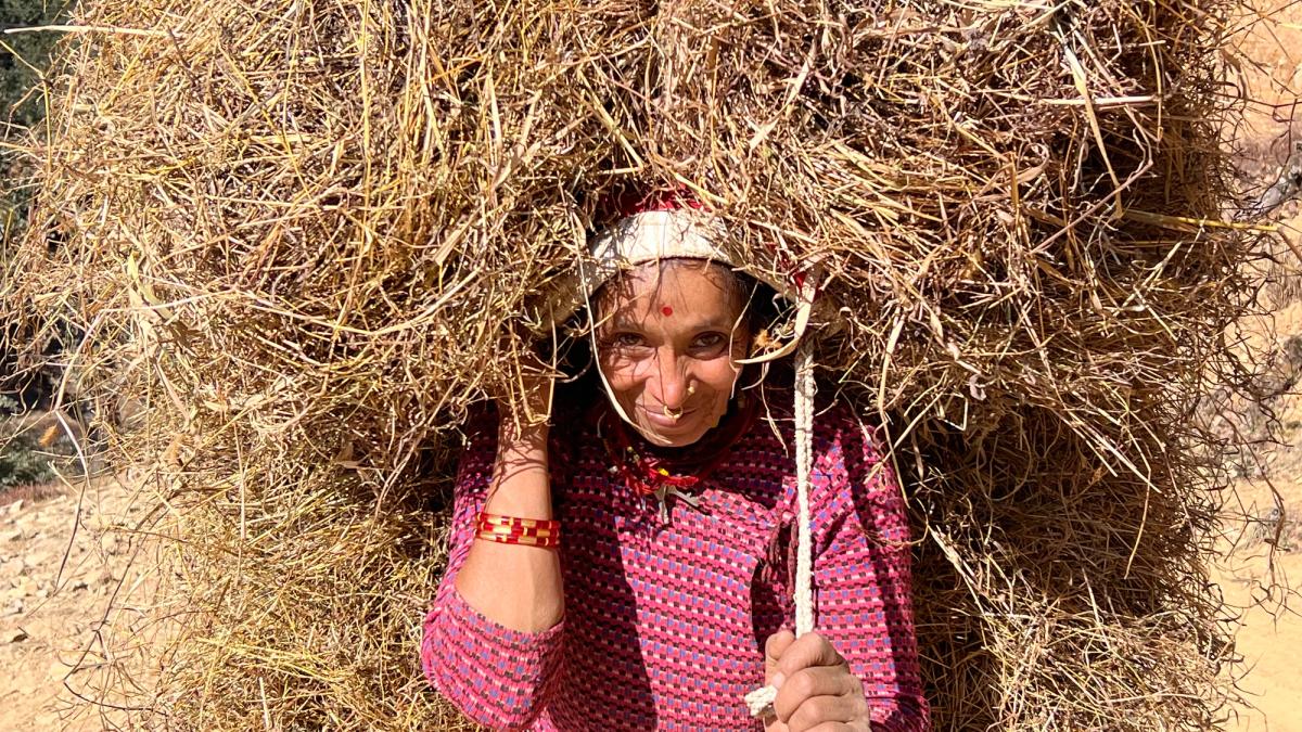 Gammel dame som bærer tungt.