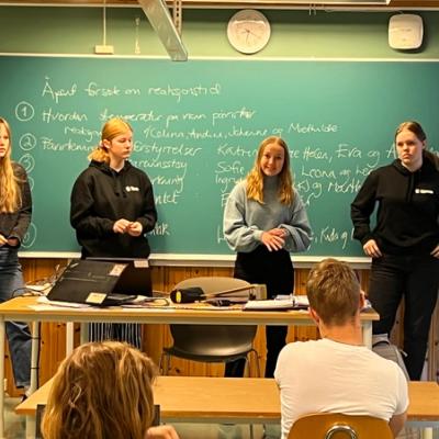 Fire elever oppstilt ved tavla. 
