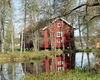 Dam og et gammelt kornmagasin på andre siden dammen.