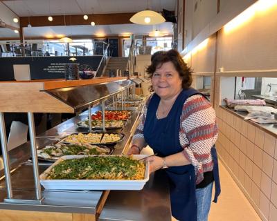 Ei dame serverer ved buffeten. 