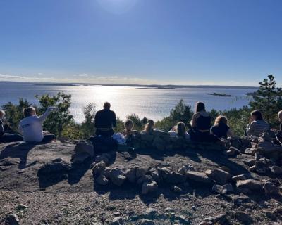 Elever sitter og ser utover havet. Nydelig vær. 