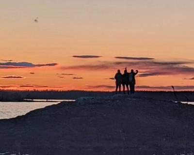 Jenter i siluett på svaberg. 