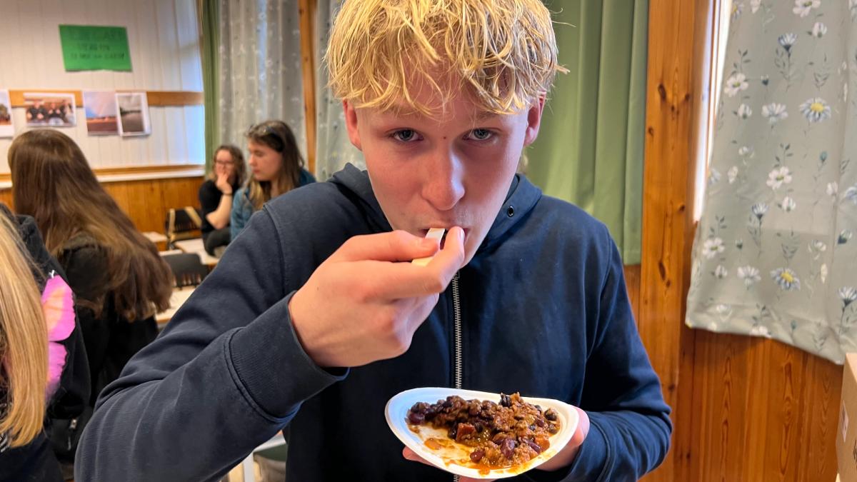Elev som smaker på chili con carne med purply