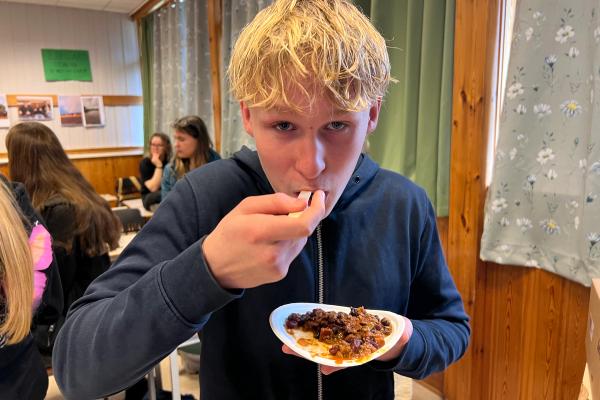 Elev som smaker på chili con carne med purply