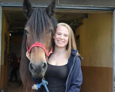 Elev og hest i stallen.