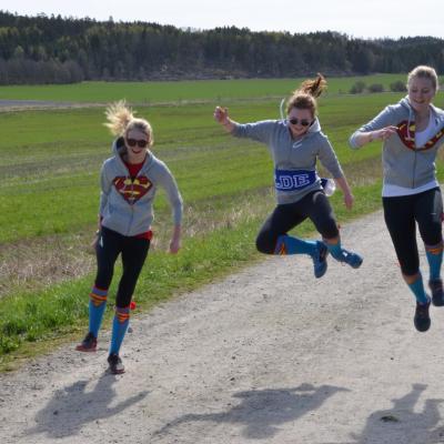 Elever som hopper av glede på en grusvei.