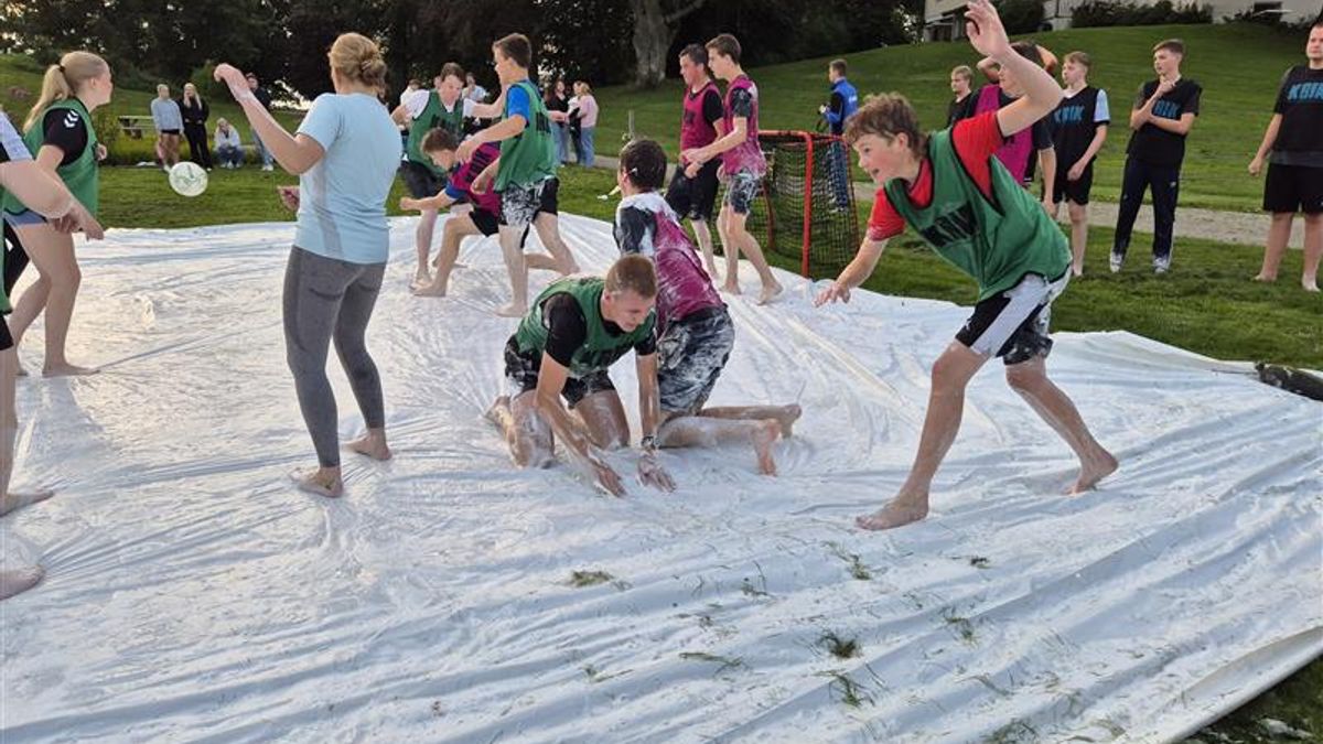 Ungdom spiller fotball på en presenning full av såpe.