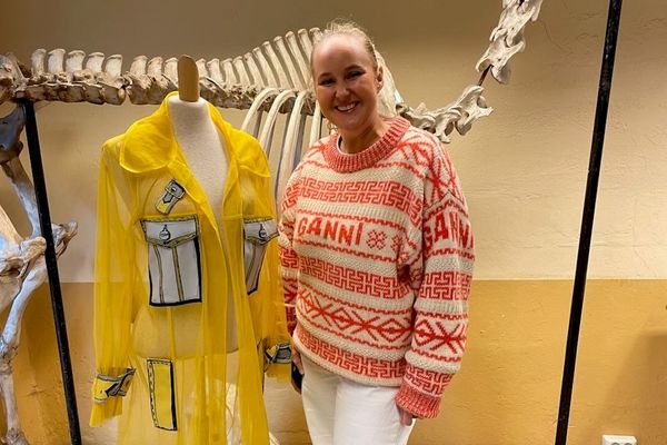 Dame ved siden av en gul kreasjon på en modellbyste.